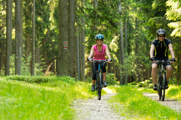 Young cheerful biker couple in woods