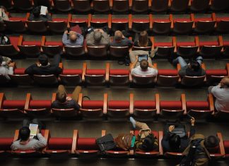 Zdjęcie przedstawia salę konferencyjną, na której siedzą ludzie.