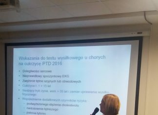 Zdjęcie przedstawia prelegentkę z mikrofonem na tle slajdu prezentacji dotyczącego wskazań do testu wusiłkowego u chorych na cukrzycę.